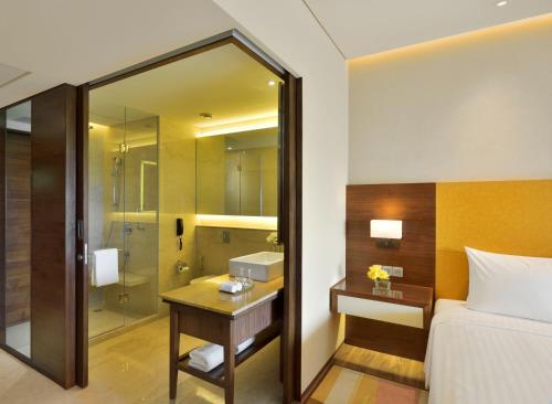 a hotel room with a bed and a bathroom at Courtyard by Marriott Raipur in Raipur