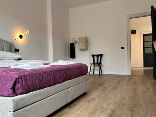 a bedroom with a bed with a purple blanket at Peaceful condo for romantic getaways near Black Church - 3min walk in Braşov