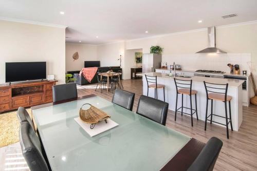 a kitchen and living room with a table and chairs at Duke Cottage - Haven near beach in Busselton