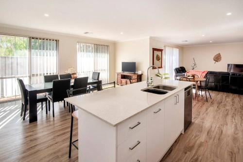 a kitchen and living room with a table and a couch at Duke Cottage - Haven near beach in Busselton