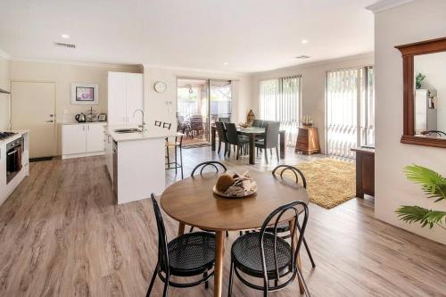 a kitchen and living room with a table and chairs at Duke Cottage - Haven near beach in Busselton