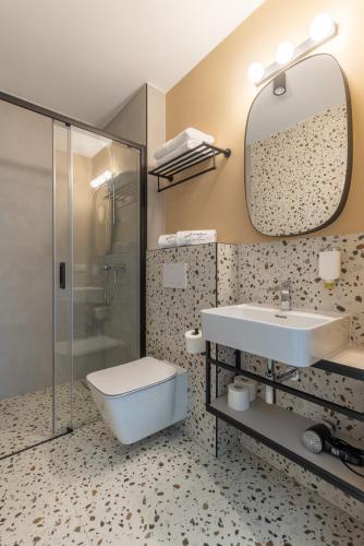 a bathroom with a sink and a toilet and a mirror at Zacisze Lubiatowo in Lubiatowo