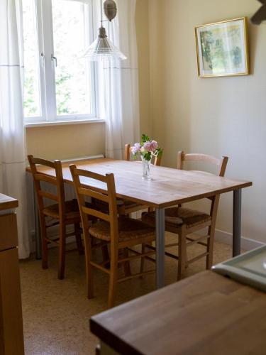 uma mesa de jantar com cadeiras e um vaso de flores em Sikfors Gästhus em Hällefors