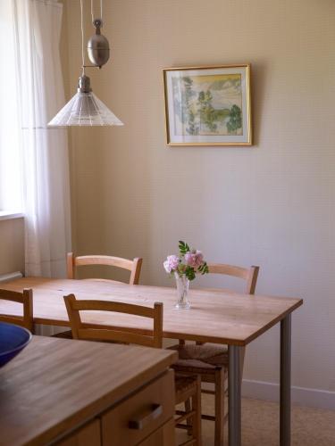 a dining room table with a vase of flowers on it at Sikfors Gästhus in Hällefors