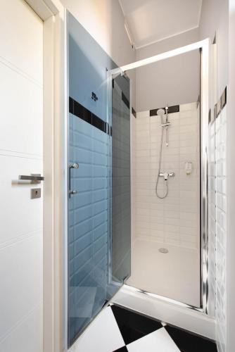 a bathroom with a shower with a glass door at By Monte Apartment - Destigo Hotels in Sopot