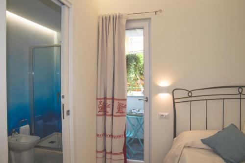 a bedroom with a bed and a bathroom with a toilet at La casa del pescatore in Cala Gonone