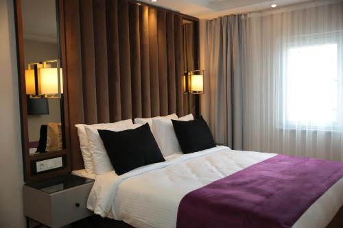 a bedroom with a large bed and a mirror at The Roomy Hotel Nişantaşı in Istanbul