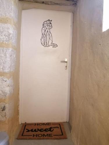 eine weiße Tür mit einer Zeichnung einer Person darauf in der Unterkunft Petit studio au coeur d'Uzès in Uzès