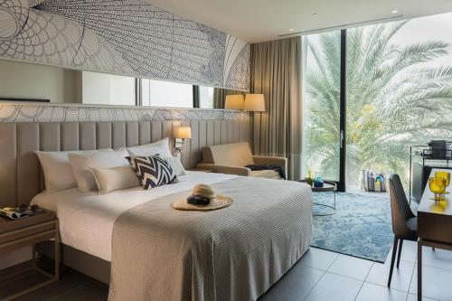 a hotel room with a bed with a hat on it at U Boutique Kinneret by the Sea of Galilee in Tiberias