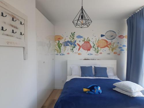 - une chambre dotée d'un lit bleu avec un jouet dans l'établissement Apartamenty Pisakowe - Apartament Śledzik, à Rowy