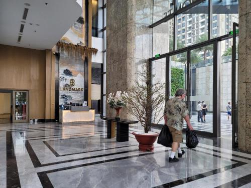 a man walking through a lobby of a building at THE LANDMARK 81 RESIDENCE LUXURY SUITE in Ho Chi Minh City