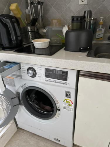y cocina con lavadora y encimera. en Condominium en Pyeongtaek
