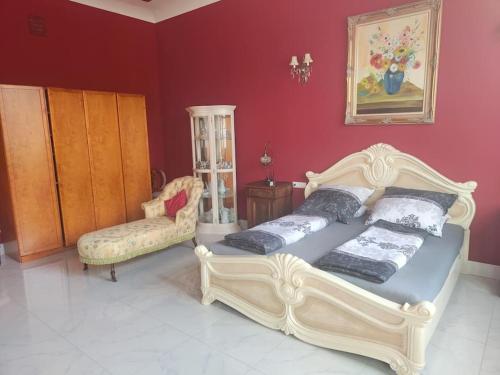 1 dormitorio con 2 camas y pared roja en Luxus Ferienwohnung/Suite in Villa D' Aragon en Gera