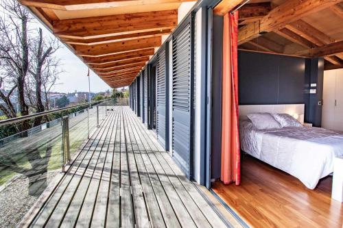 a bedroom on a balcony with a bed on a deck at Casa Itram Fantástica casa en el Gironès in Girona