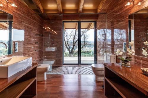y baño con 2 aseos, bañera y lavamanos. en Casa Itram Fantástica casa en el Gironès en Girona