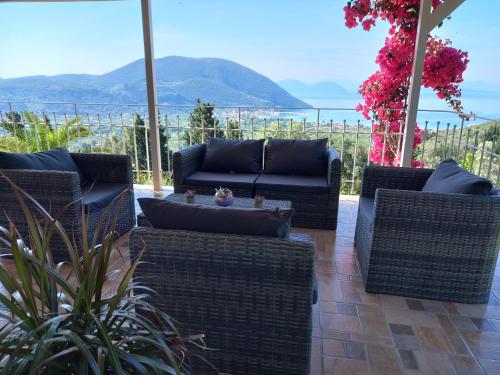 a patio with wicker furniture and a view of the ocean at Vasiliki View in Áyios Pétros