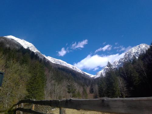 Blick auf schneebedeckte Berge mit einem Zaun in der Unterkunft Glamping Grintovec 