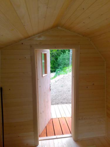 una puerta abierta a una habitación en una cabaña de madera en Glamping Grintovec, 