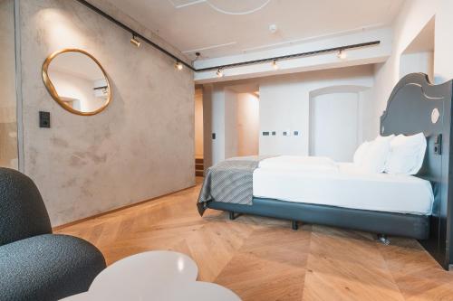 a bedroom with two beds and a mirror at H5 Grauer Bär Studios & More in Innsbruck
