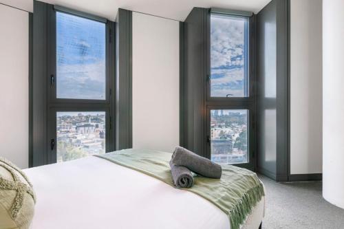 a bedroom with a white bed with windows at Your Gateway to Sports and Entertainment-00215 in Melbourne