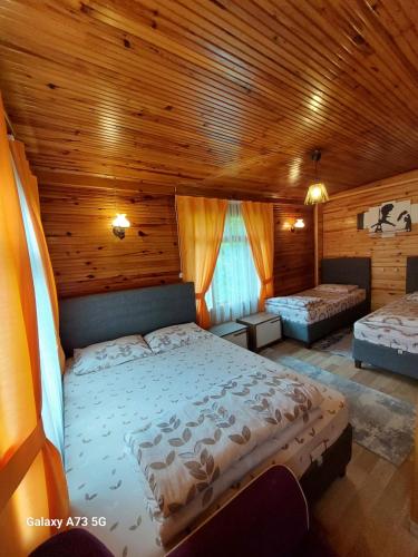 sypialnia z dużym łóżkiem i drewnianym sufitem w obiekcie AYDER Nazlı çiçek apart w mieście Ayder Yaylasi