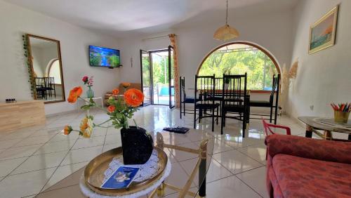 a living room with a vase of flowers on a table at SWIM and CLIMB BAŠKA HOLIDAY HOUSE - island KRK in Draga