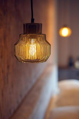 a yellow pendant light hanging over a bed at The Yard hotel Noordkade in Veghel