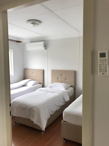 2 bedden in een kamer met witte lakens bij SEYRİ DENİZ VİLLA Villa with sea view in Trabzon