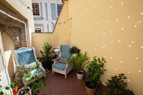 2 chaises assises sur un balcon avec des plantes dans l'établissement Women's Only Hostel - Female Only, à Prague