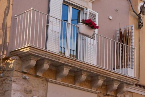 balkon z doniczką i oknem w obiekcie La casa di Nina w mieście Pozzallo