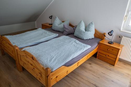 1 dormitorio con cama de madera y almohadas en FeWo Sabine, en Ebern