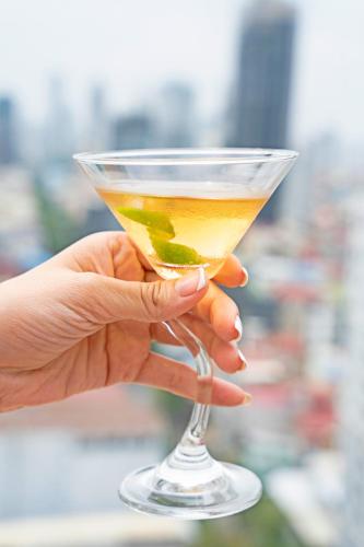 a person holding a drink in a martini glass at Poulo Wai Hotel & Apartment in Phnom Penh