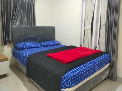 Un dormitorio con una cama con una almohada roja. en Bromo Semesta Guesthouse en Probolinggo