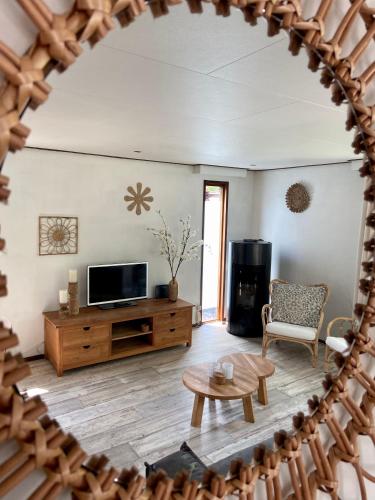 a living room with a tv and a table at Bungalowpark Het Verscholen Dorp in Harderwijk