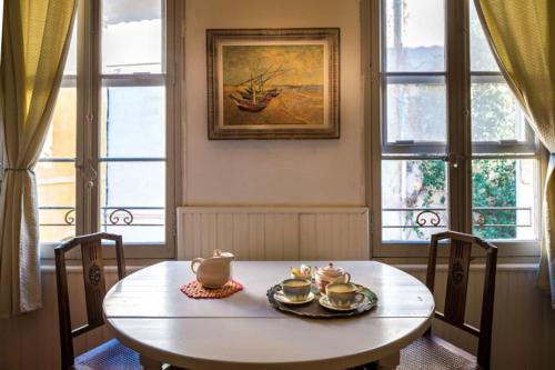 - une table avec de la vaisselle dans une chambre avec des fenêtres dans l'établissement Gipsy - chambre déco Van Gogh pour 1, 2 ou 3 pers, à Arles