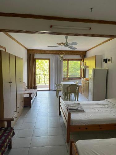 a room with two beds and a kitchen with a table at Exohi apartments in Nea Vrasna