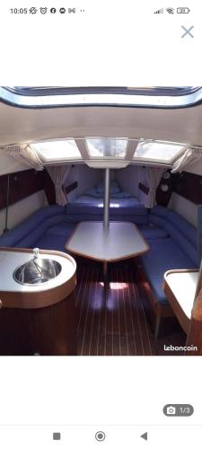 une pièce avec une table et un lavabo sur un bateau dans l'établissement Bateau a quai St Raphaël, 4 couchages , voilier Etap 28i, à Saint-Raphaël