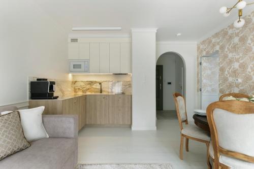a living room with a couch and a kitchen at Willa Szwarc by Elite Apartments in Sopot