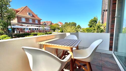 a table and chairs on the balcony of a house at 'Dörpnüst' in Langeoog