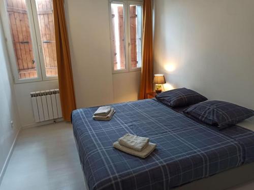 Un dormitorio con una cama azul con toallas. en Chez Mylène et J-P en Orange