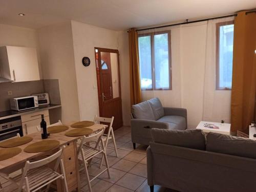 cocina y sala de estar con mesa y sofá en Chez Mylène et J-P en Orange