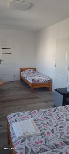 a room with two beds and a door in it at UniBal - pokoje gościnne in Unieście