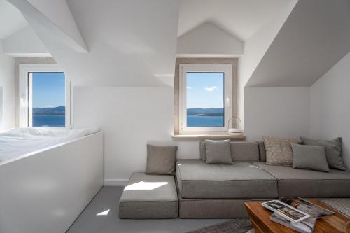 a living room with a couch and two windows at Murvica resport in Murvica