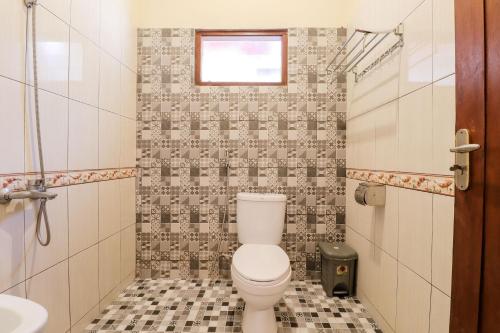 uma casa de banho com um WC e um lavatório em Hotel Ndalem Ayem Syariah em Magelang