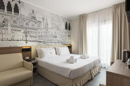 une chambre d'hôtel avec un lit et une chaise dans l'établissement Hotel Marco Polo, à Lido di Jesolo