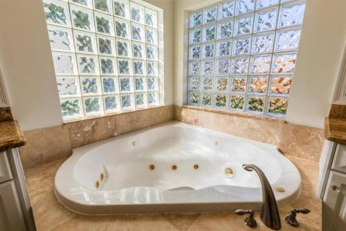 a bath tub in a bathroom with a large window at Pineapple Palms Resort Style Pool Villa! Sleeps 12 in West Palm Beach