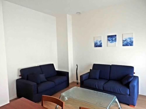 uma sala de estar com dois sofás azuis e uma mesa em Carla's House em Bolsena