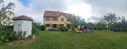 uma casa com um quintal com cadeiras e uma casa em L'auberge d'authie em Authie