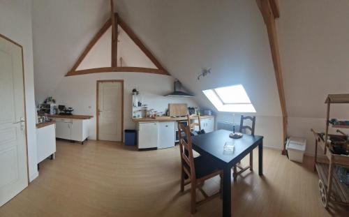 um quarto com uma mesa e uma cozinha num sótão em L'auberge d'authie em Authie