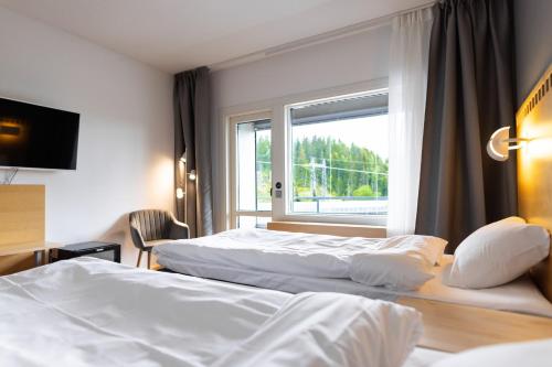Cette chambre comprend 2 lits et une fenêtre. dans l'établissement Hotelli Siuntio, à Sjundeå